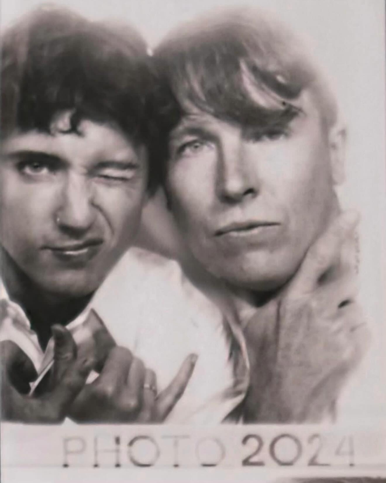 Monochrome close-up of two adult men, one winking, in a photo booth-style image with 'PHOTO 2024' text, evoking a vintage aesthetic.