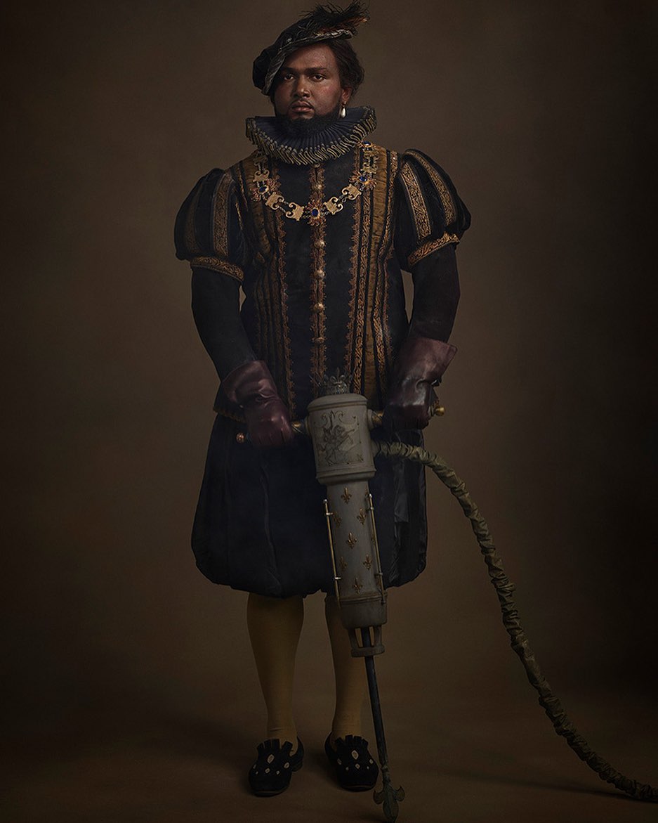 Man in historic costume holding a jackhammer. The composition features warm, neutral colors with the man as the primary subject.