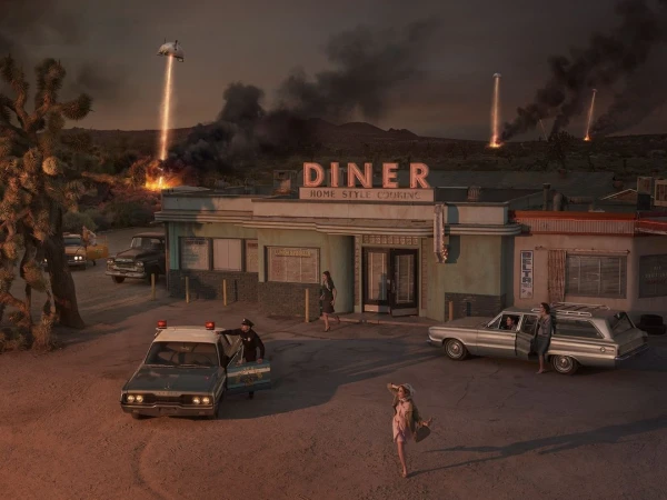 Cinematic aerial view of a vintage diner under attack with hovering craft, fire, and smoke by Sacha Goldberger