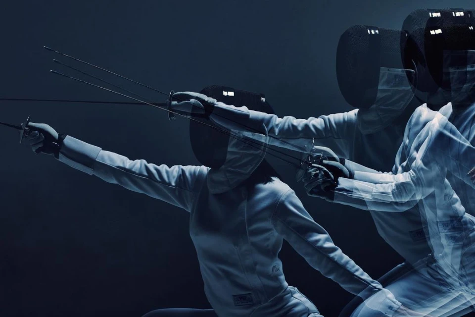 A dynamic action shot captures a fencer in motion, wearing protective gear and wielding a foil, set against a dark, contrasting backdrop.