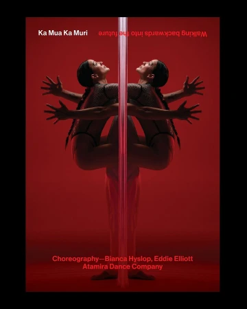 Artistic studio shot of a female dancer performing a pole routine in a red studio setting. The dancer is reflected off the pole.