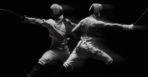 Black and white action photograph of two fencers in protective masks and uniforms lunging against a dark background.