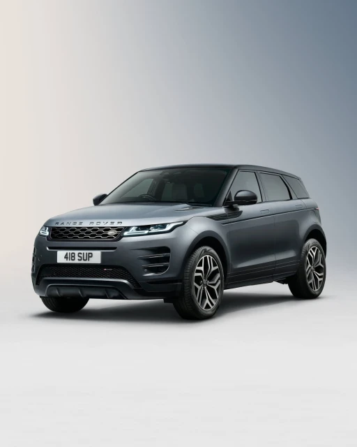 Grey Range Rover Evoque three-quarter studio shot with black wheels and roof, silver grille, and ‘Range Rover’ nameplate on the hood.