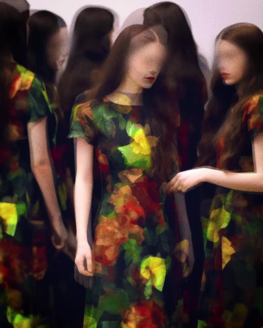 Several women in floral print dresses, artful blur effect, long dark hair, red lipstick, set against a stark white background.