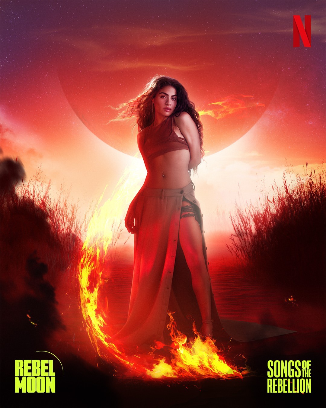Woman in crop top and skirt poses with fire effect on a sunset-colored movie poster for 'Rebel Moon: Songs of the Rebellion'.
