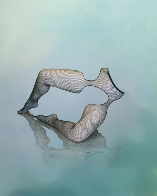 Abstract fashion art featuring a pair of legs in fishnet stockings bent to form a mirrored lip shape against a gradient blue backdrop.