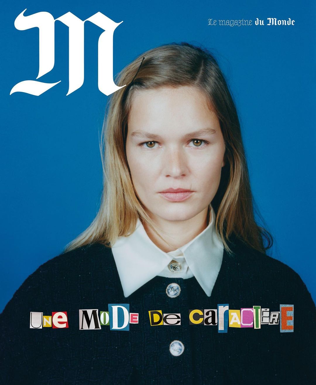 Magazine cover featuring a woman with blonde hair, wearing a dark jacket with a white collar against a blue background. The title is visible.