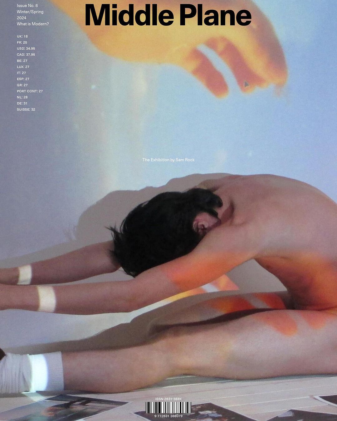 Magazine cover featuring a person stretching with painted orange accents, against a blurred background with overlaid text.