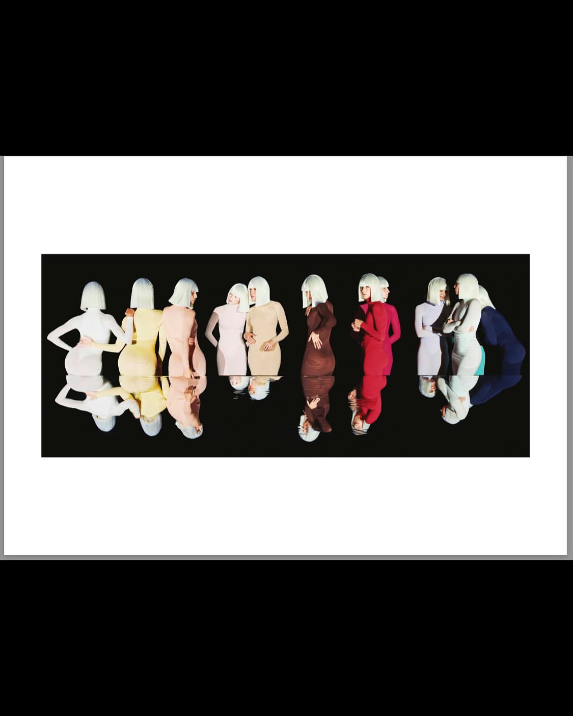 Group of women in color-coordinated dresses and white wigs standing in a mirrored formation against a black background, fashion shot.