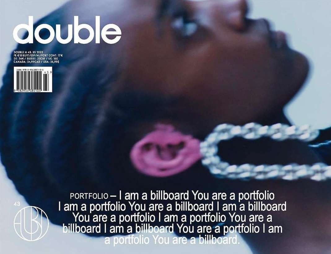 Close-up portrait of a Black woman wearing large chain earrings against a pale blue background for a magazine cover.