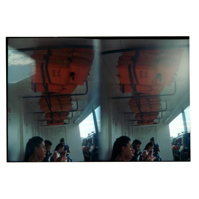 Passengers on a boat interior, with stacks of life vests overhead, creating a sense of travel and maritime safety.