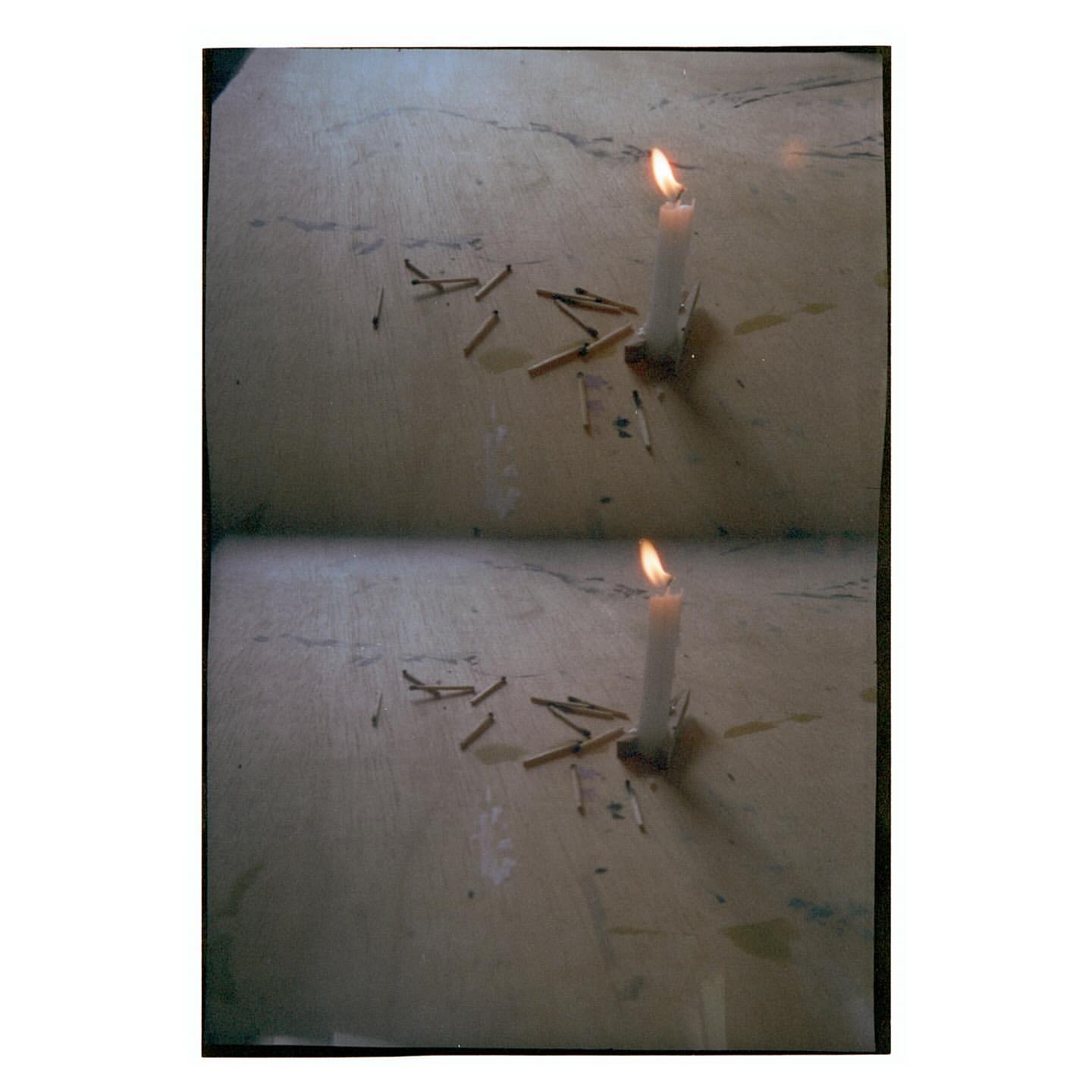 Candle burns on a textured surface with used matches scattered around, duplicated to show two identical scenes in a single frame.