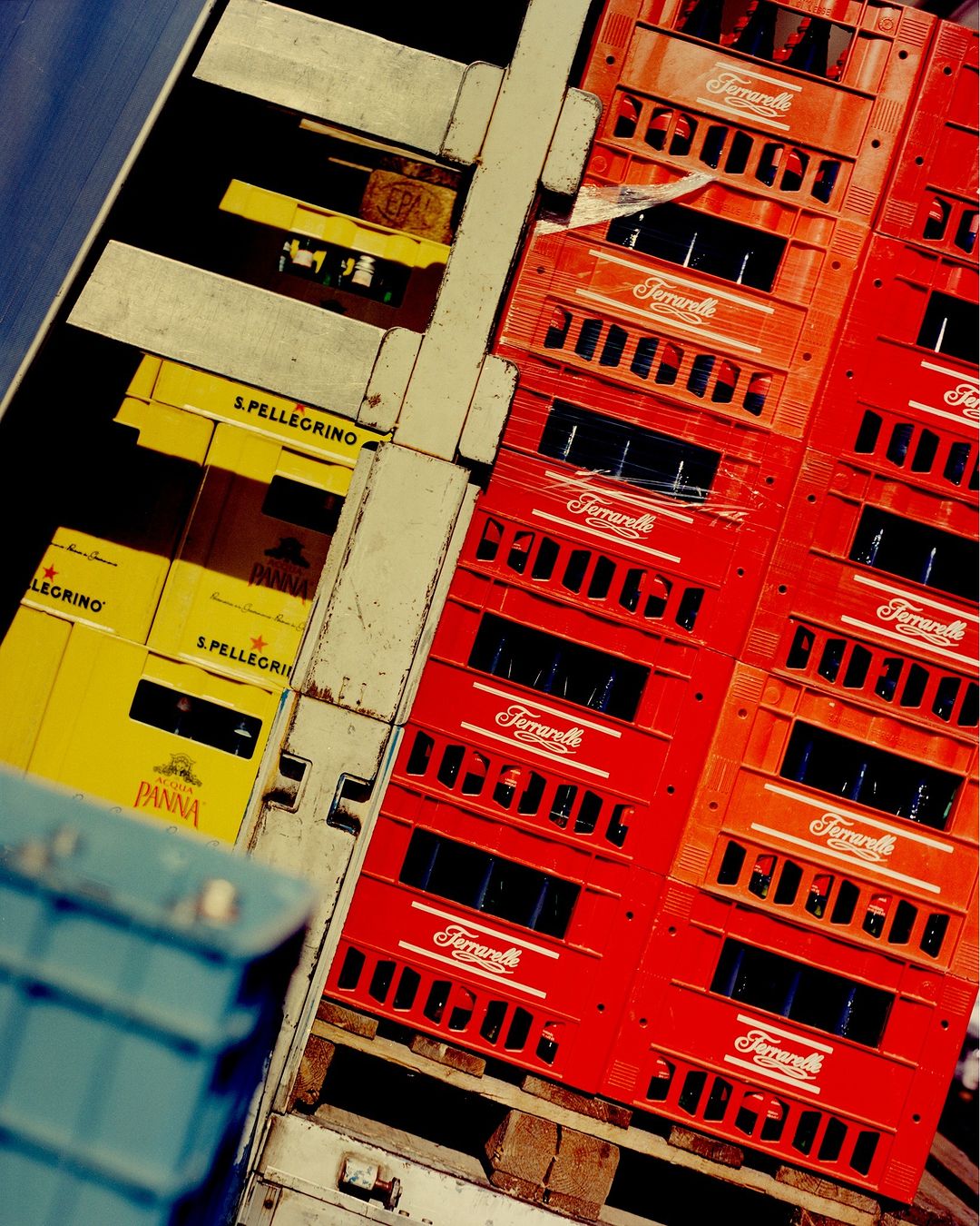 Stacked crates of bottled water feature red and yellow color schemes, creating a visually striking pattern in an indoor setting.