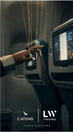 Conceptual image of a wooden puppet hand with strings in an airplane cabin, next to a Cathay Pacific entertainment screen.