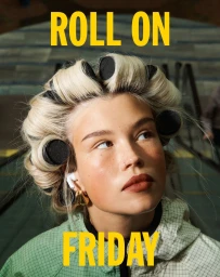 Close-up portrait of a young woman wearing hair rollers and earbuds, looking upwards beneath bold yellow typography.