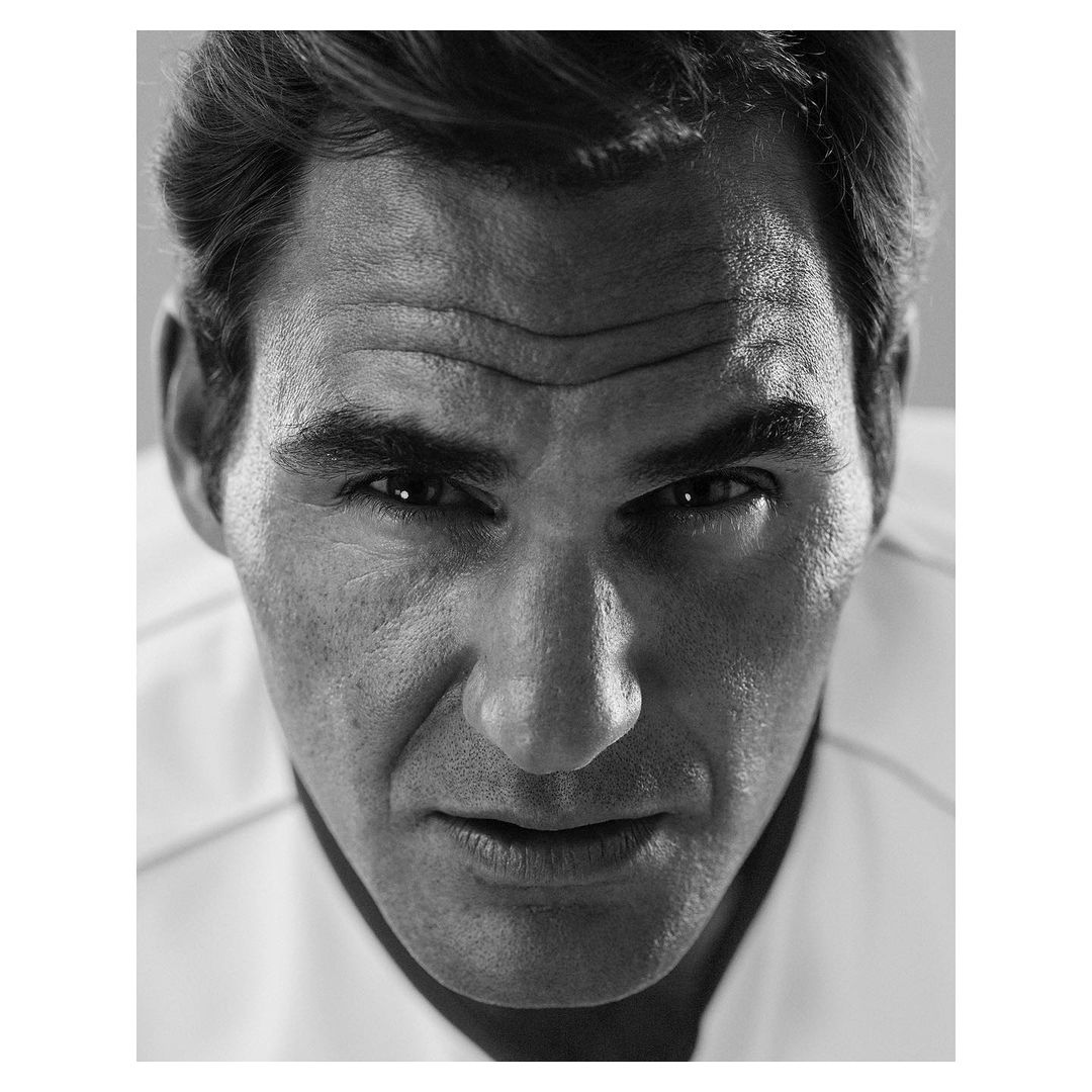 Black and white close-up portrait of an adult male with short dark hair, a neutral expression, wearing a light-colored shirt.