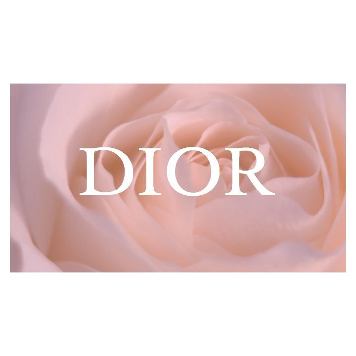 Close-up of a pink rose with the 'DIOR' logo overlaid in white, set against a soft, blurred floral background.