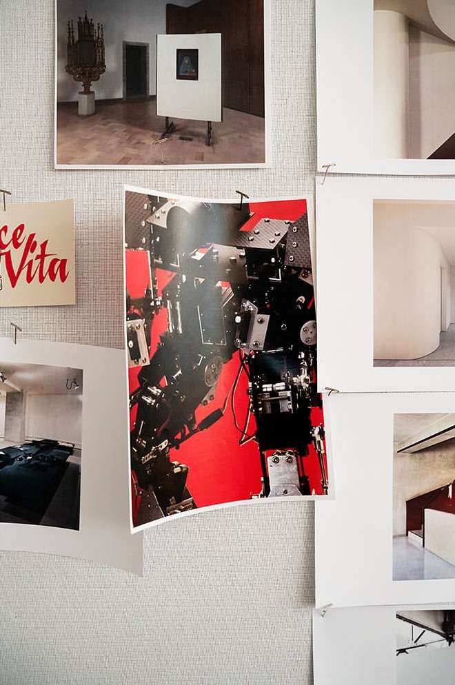 Display board featuring photography, including art and interior design subjects, creating a collage-like effect in a well-lit, neutral space.
