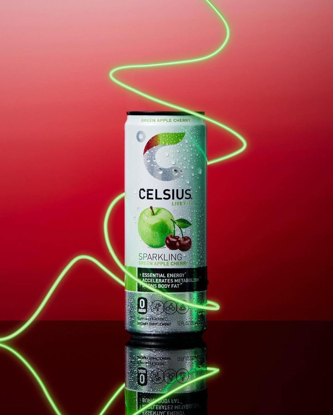 Celsius brand energy drink can featuring green apple cherry flavor with studio lighting and a red background.