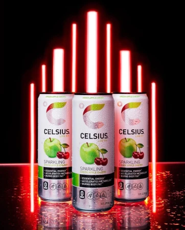 Three cans of Celsius brand sparkling green apple cherry energy drink with red LED bars in the background against a black backdrop.