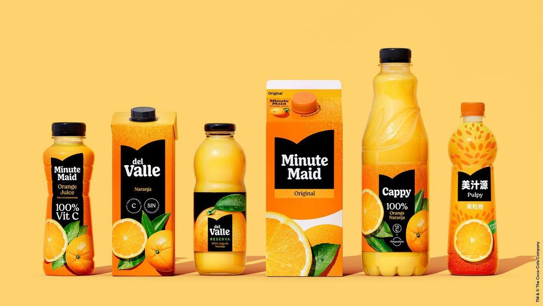Variety of branded orange juice containers including Minute Maid, del Valle, and Cappy lined up on a seamless yellow background.