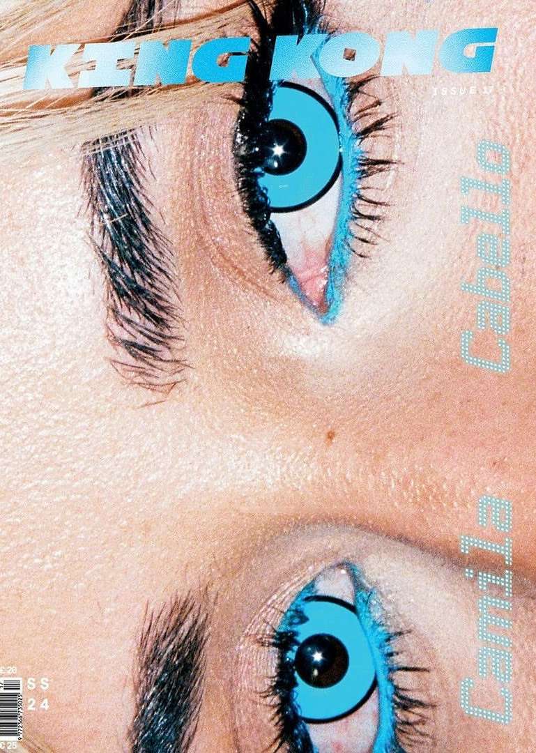 Macro shot of a magazine cover featuring a close-up of a woman's eye with blue contact lenses and vibrant blue eye makeup.
