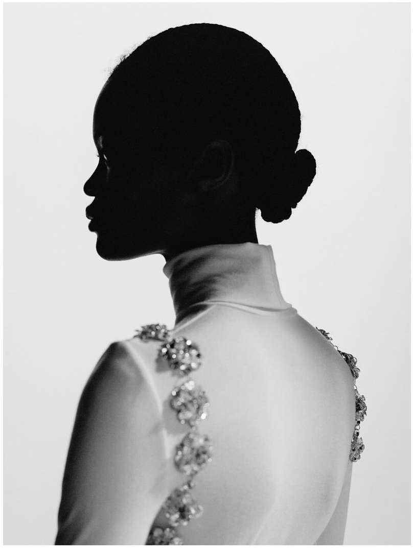 Profile of an adult woman in a white high-neck dress with jeweled accents. The image is a black-and-white studio portrait.