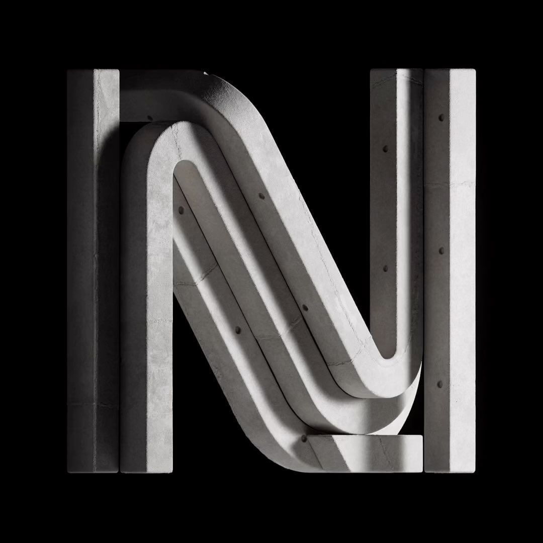 Concrete letter N with strong shadows against a black background, showcasing textures and structural form.
