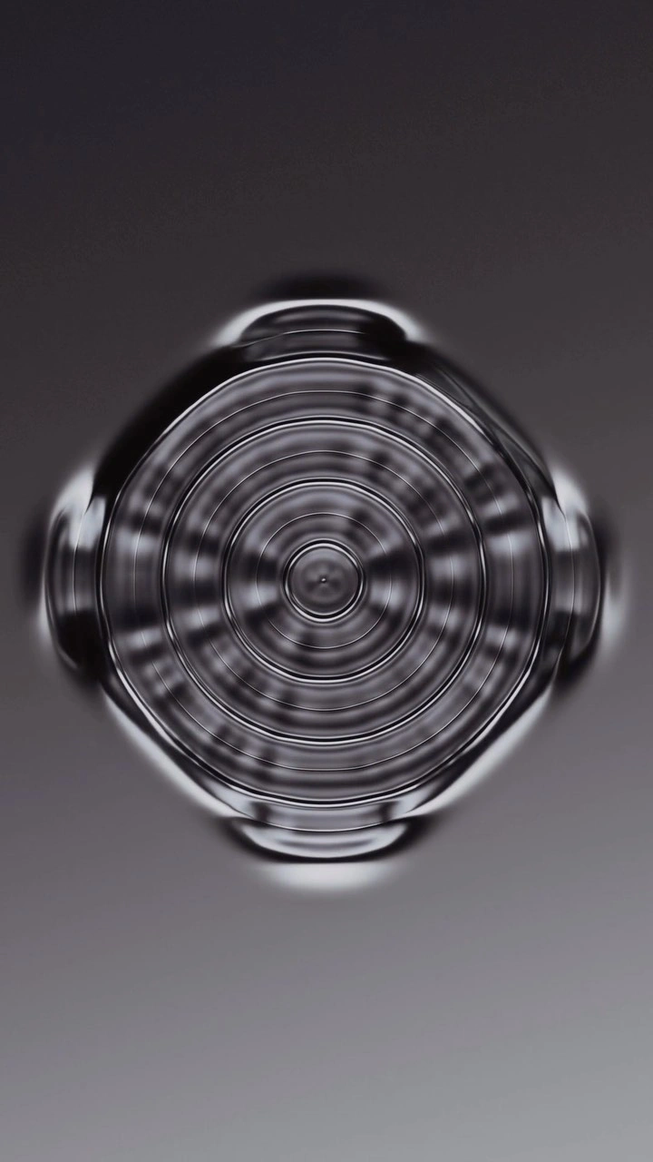 Abstract 3D render by Sawdust featuring concentric metallic ripple patterns on a smooth dark grey gradient surface