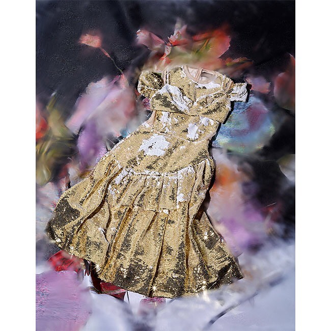 Sequin-covered short-sleeve tiered dress in gold and white against a mottled floral background suggesting a fashion editorial.