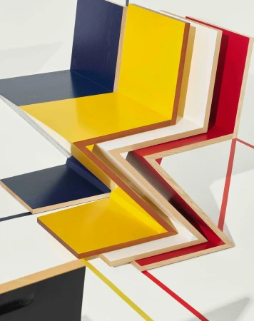 Abstract geometric composition with primary colors, wood frames, and a dynamic zig-zag pattern on a clean white background.