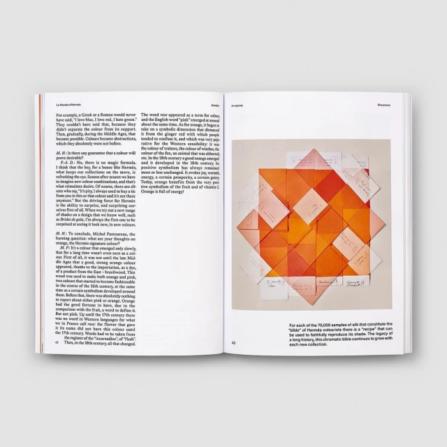 Open book displays orange geometric paper art on right page, accompanied by text on both pages, all set against a white background.
