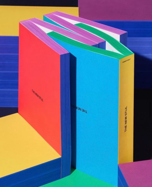 Abstract colorful book arrangement. Bright red, blue, green, yellow and purple books positioned in a geometric layout.