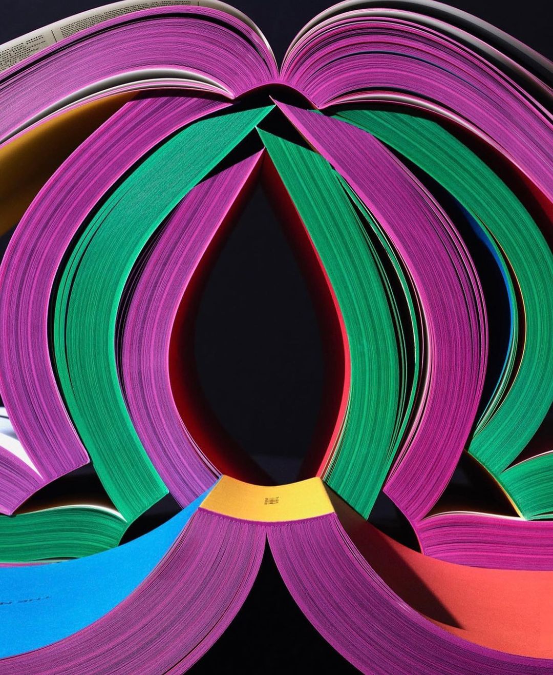 Abstract composition featuring colorful book pages arranged in an eye-catching pattern against a dark backdrop.