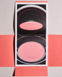 Hermes pink powder compact in a coral paper box photographed by Scheltens and Abbenes.