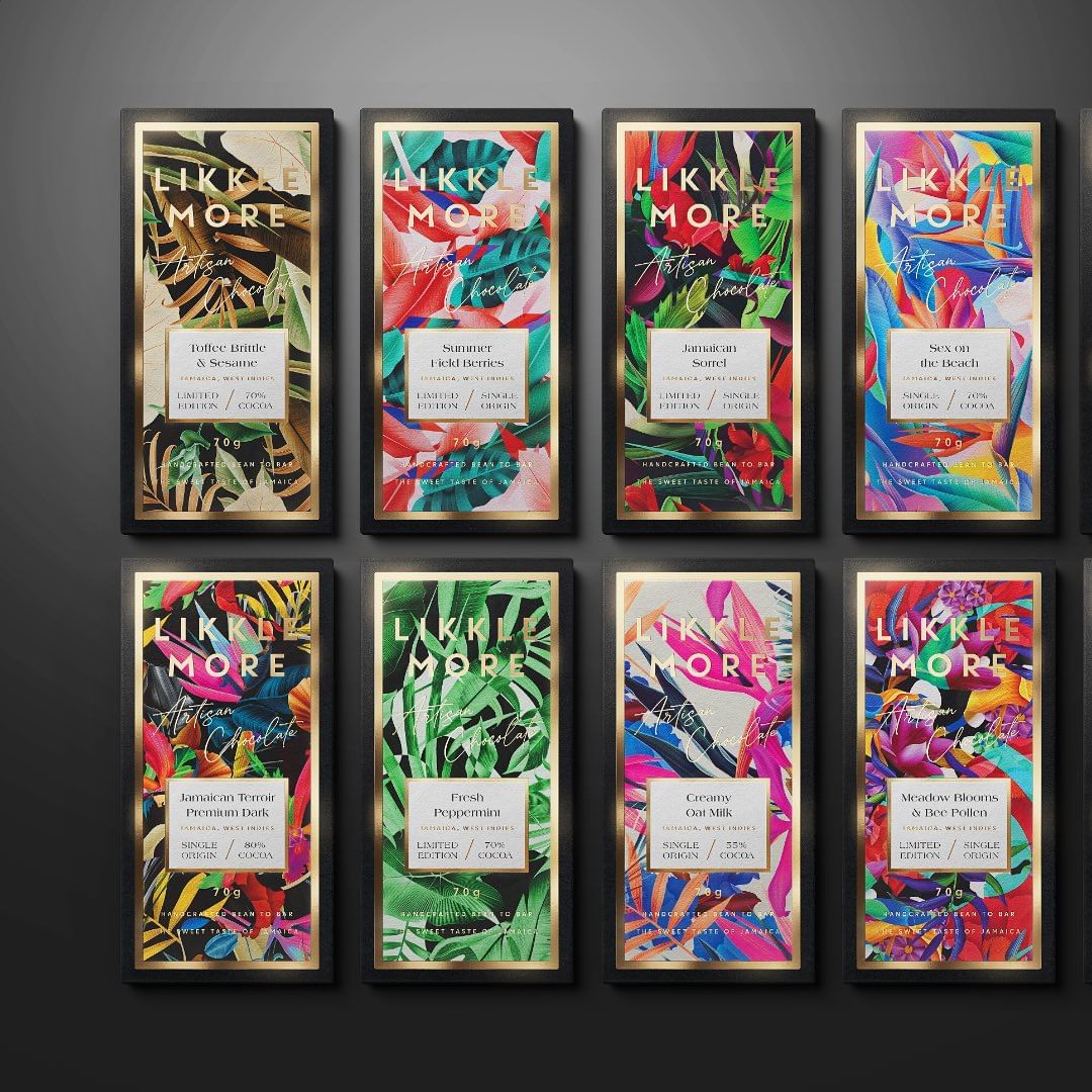 Eight chocolate bars with colorful botanical designs and gold frames are displayed against a dark gray background.
