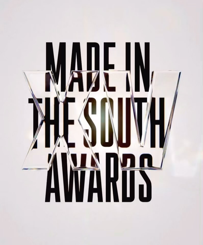 Three triangular glass sculptures sit atop dark typography that reads 'Made in the South Awards' on a bright white background.