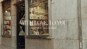 Exterior view of a storefront with greeting cards visible in the window display, as well as text that reads 'WITH LOVE, TO YOU.'