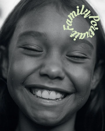 A close-up, black and white portrait of a smiling child with closed eyes, featuring light green text overlay that reads 'Family Portrait'.