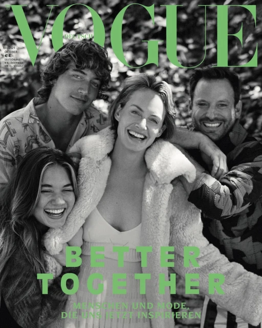 Vogue cover featuring four smiling people huddled together outdoors; fashion magazine cover showcases a group of diverse individuals.