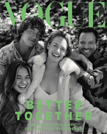 Vogue cover featuring four smiling people huddled together outdoors; fashion magazine cover showcases a group of diverse individuals.