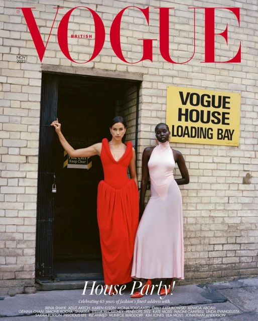 Vogue magazine cover featuring models Irina Shayk and Adut Akech in formal dresses against a brick building with signage.