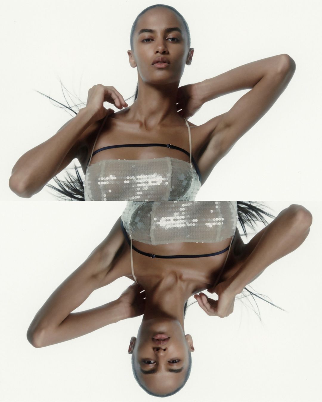 Fashion shot featuring an adult female model posing in a sparkling tank top against a white background, with a reflected twin effect.