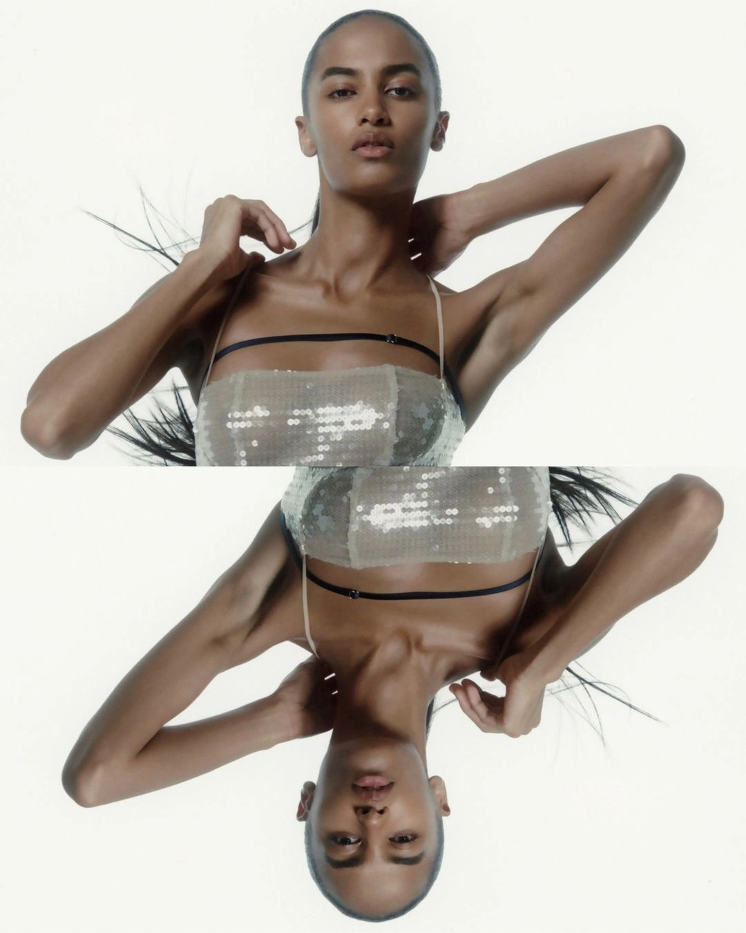 Symmetrical mirrored portrait of a woman with dark hair wearing a sparkly sequin bandeau top against a plain white background.