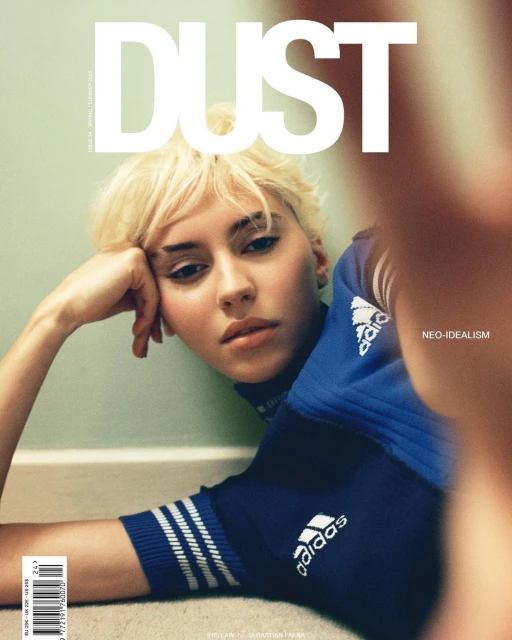 Magazine cover featuring a young woman with blonde hair and blue athletic apparel, posing against a neutral background with bold text.