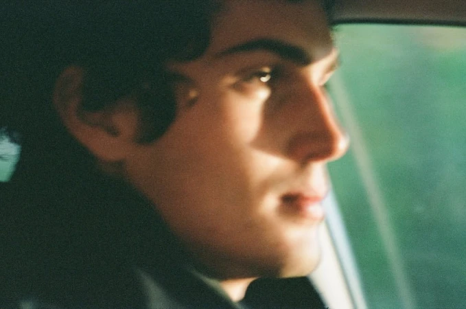 Close-up portrait of a man in profile sitting inside a car captured by photographer Sebastian Faena.