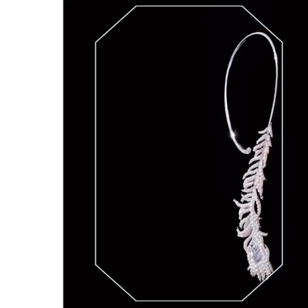Close-up studio shot of a striking silver choker necklace featuring a feather design adorned with sparkling diamonds against a black background.