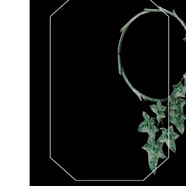 Elegant emerald necklace with leaf-shaped pendants, beautifully displayed against a stark black background, emphasizing luxury jewelry design.