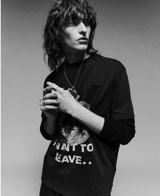 Monochrome portrait of a young man with shaggy dark hair wearing a graphic t-shirt and rings, photographed by Sebastien Giraud
