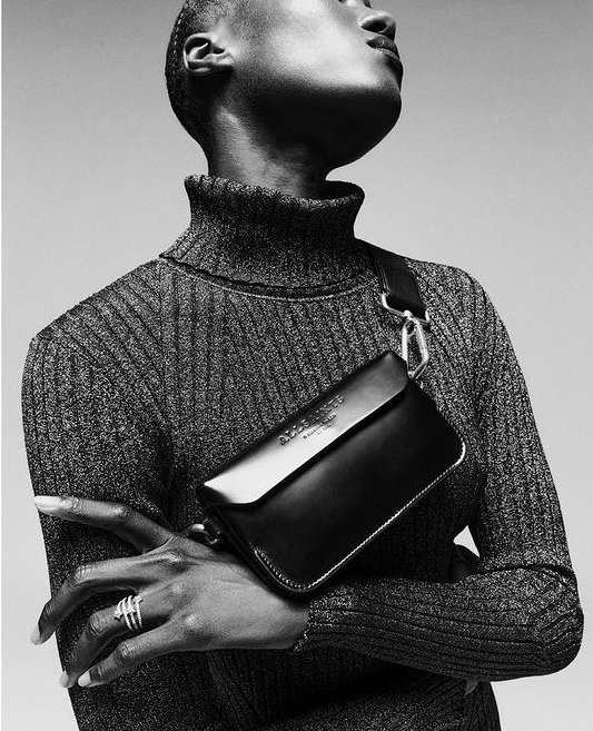 Black and white portrait of a black woman wearing a turtleneck sweater and a black crossbody bag by Sebastien Giraud